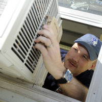 man repairing an AC unit